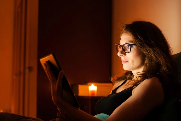 Pretty woman surfing web on a tablet in bed before sleeping — Stock Photo, Image