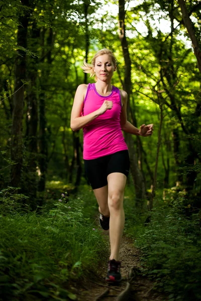 Hermosa joven corre en el camino del bosque — Foto de Stock