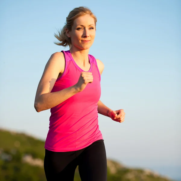 Beautiful young woman runns cross country on a mountian path at — Stock Photo, Image