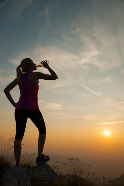 Beautiful young woman runns cross country on a mountian path at — Stock Photo, Image