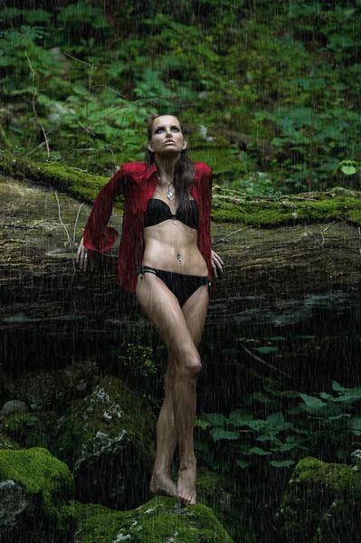 Femme à la mode dans la forêt sombre près de la rivière — Photo