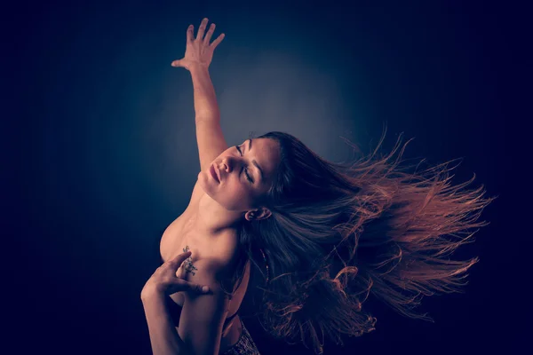 Молода брюнетка біла жінка танцює і її волосся тече в повітрі — стокове фото