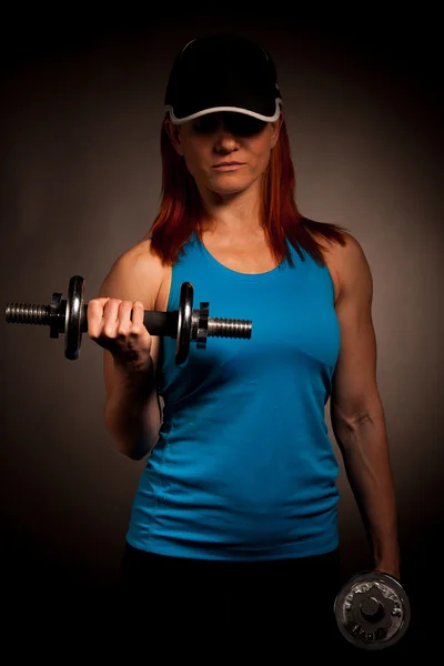 Beautiful young woman working out with dumbels in fitness gym — Stock Photo, Image