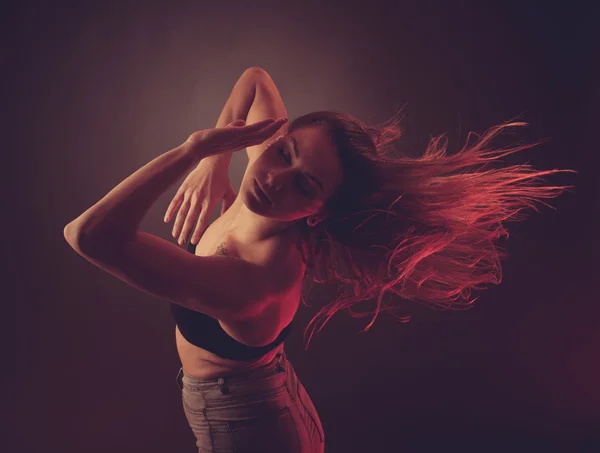 Jonge brunette Kaukasische vrouw dansen en haar stroomt door de lucht — Stockfoto