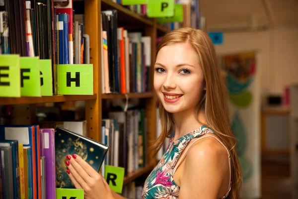 Όμορφη νεαρή γυναίκα φοιτητής στη βιβλιοθήκη — Φωτογραφία Αρχείου