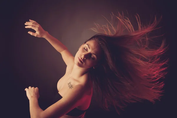 Jovem morena caucasiana dançando e seu cabelo fluindo pelo ar — Fotografia de Stock