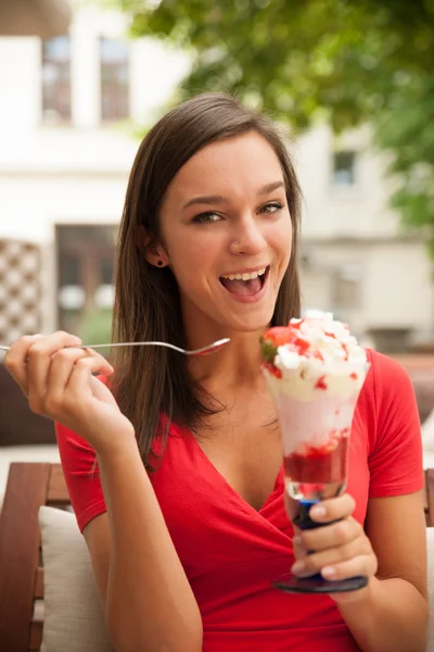 Vrouw eet zoete aardbei fruitsalade op een bankje buiten in ba — Stockfoto