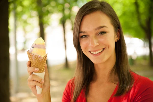 Woman eats sweet ice cream outdoor in park — Stock Photo, Image