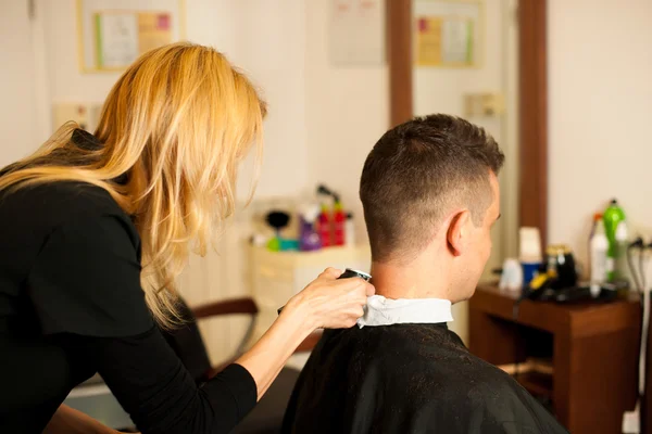 Friseurin schneidet dem lächelnden Mann die Haare — Stockfoto