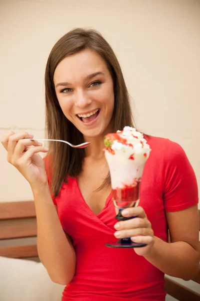 Vrouw eet zoete aardbei fruitsalade op een bankje buiten in ba — Stockfoto