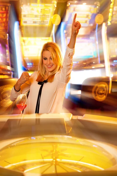 Junge blonde Frau spielt Roulette im Casino und gewinnt — Stockfoto