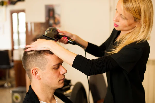 Friseurin schneidet dem lächelnden Mann die Haare — Stockfoto