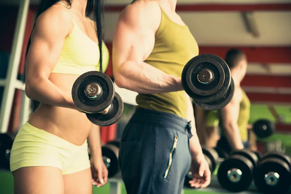 Fitness casal exercitando-se no ginásio com halteres — Fotografia de Stock