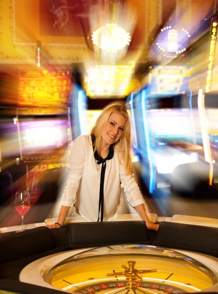 Ung blond kvinna spela roulette på casino och vinnande — Stockfoto