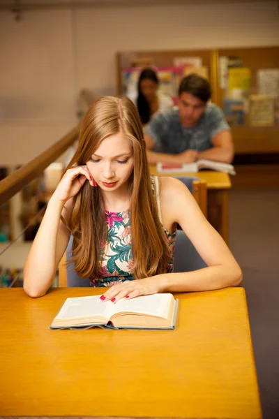 Mooie jonge vrouw student in bibliotheek — Stockfoto