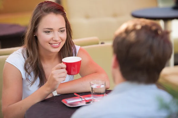 Jovem homem e mulher bebendo café ao ar livre e ter uma conversa em — Fotografia de Stock