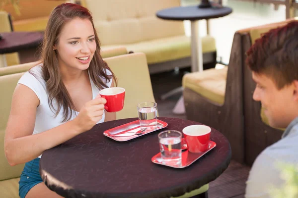 Jovem homem e mulher bebendo café ao ar livre e ter uma conversa em — Fotografia de Stock