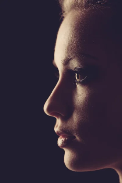 Silueta de retrato de mujer en oscuridad con luz suave en la cara . — Foto de Stock