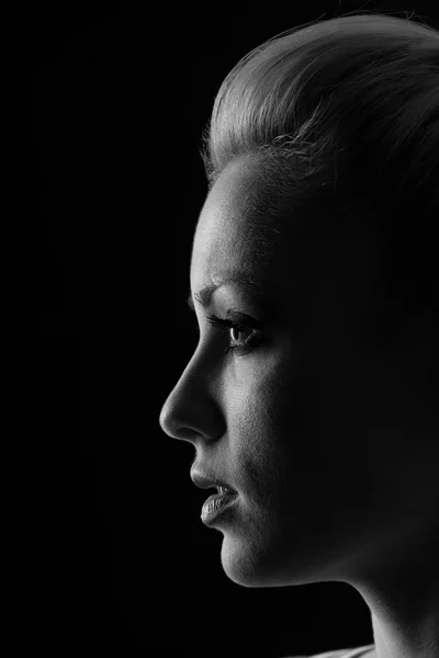 Silueta de retrato de mujer en oscuridad con luz suave en la cara . — Foto de Stock