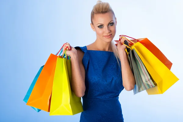 Boldog szőke nő gazdaság csomó után élénk bevásárló táskák — Stock Fotó