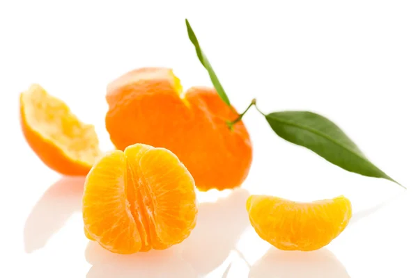 Spiral peel of orange mandarin with green leafs and a slice of c — Stock Photo, Image