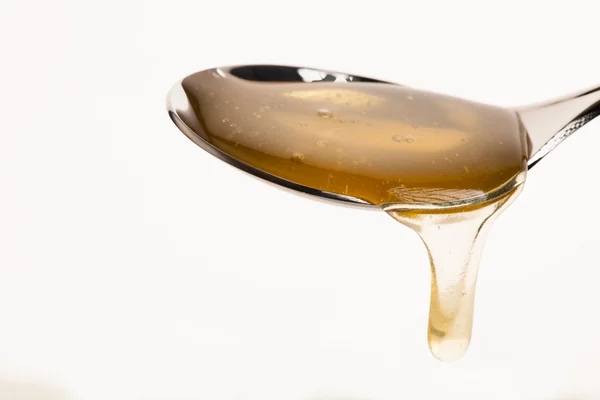 Colher cheia de mel dourado doce isolado sobre backgro branco — Fotografia de Stock