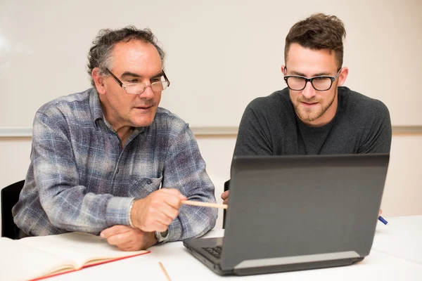 Junger Mann, der dem älteren Mann die Benutzung des Computers beibringt. intergenerat — Stockfoto