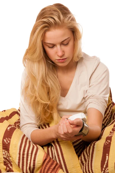 Sick woman sitting on bad wrapped in a blanket feeling ill, has — Stock Photo, Image