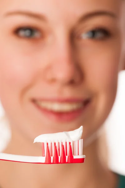 Mujer sosteniendo cepillo de dientes delante de los dientes promoviendo la boca hygie — Foto de Stock