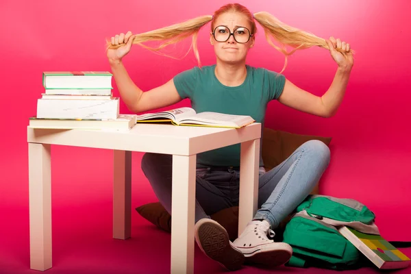 Frustrated schoolgirl with big eyeglasses pulling hair tails not — Zdjęcie stockowe