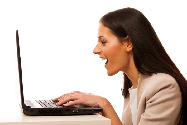 Opgewonden vrouw op zoek naar een laptopcomputer. — Stockfoto