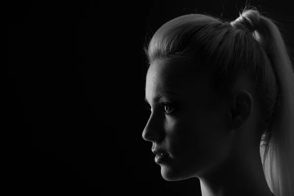 Vrouw staand silhuette in duisternis met zacht licht op gezicht. — Stockfoto