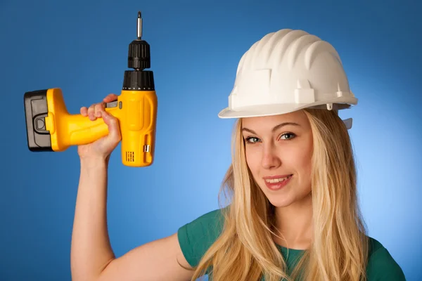 Mujer con casco de constructor y llave eléctrica feliz de hacer —  Fotos de Stock