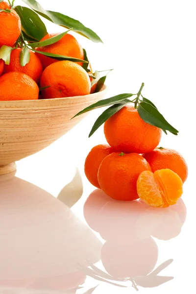 Wooden bowl filled with fresh orange mandarin citrus fruit with — Stock Photo, Image