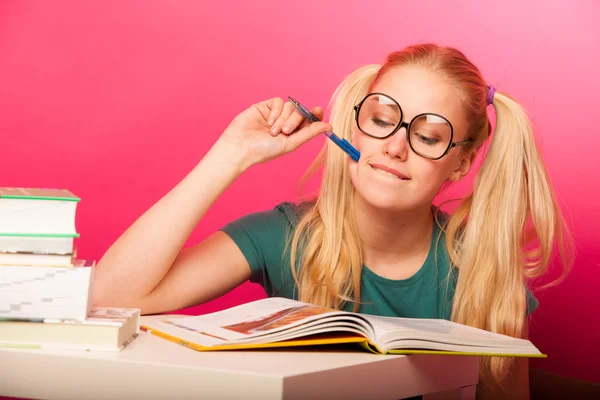 Kurioses, verspieltes Schulmädchen mit zwei Haarschwänzen auf dem Boden sitzend — Stockfoto