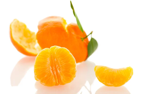 Spiral peel of orange mandarin with green leafs and a slice of c — Stock Photo, Image