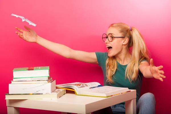 Грайлива, неслухняна школярка з великими окулярами грає з папером — стокове фото