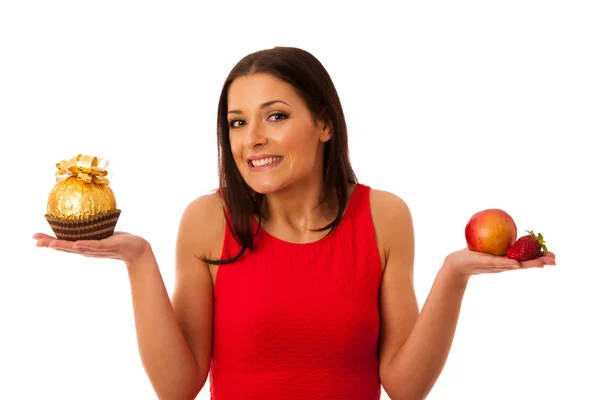 Frau entscheidet sich für gesundes Obst oder Schokolade. — Stockfoto