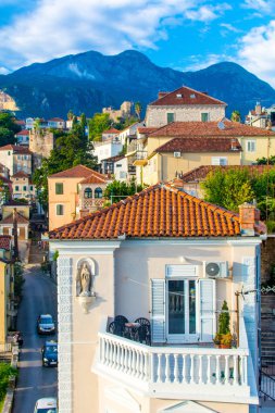 Herceg Novi, Karadağ, 30 Ağustos 2018. Dağların arka planına karşı şehrin kiremitli çatısı olan güzel beyaz bir ev.