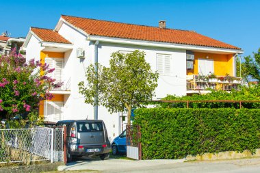 Herceg Novi, Karadağ, 30 Ağustos 2018. Turuncu döşemeli ve parlak yeşil çitli güzel beyaz villa.