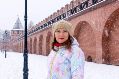 Rusya, Tula. 9 Ocak 2021. Kışın Tula Kremlin 'in kırmızı tuğla duvarları ve kuleleri. Kalenin duvarları içinde bir kadın turist.