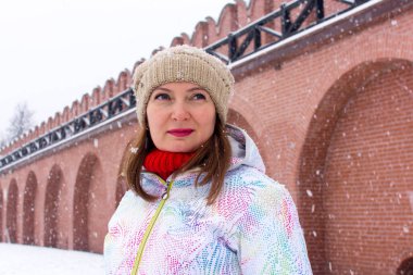 Rusya, Tula. 9 Ocak 2021. Kışın Tula Kremlin 'in kırmızı tuğla duvarları ve kuleleri. Kalenin duvarları içinde güzel bir kadın turist..