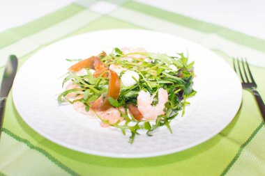 Beyaz tabakta taze yeşil karides ve yeşillik salatası.