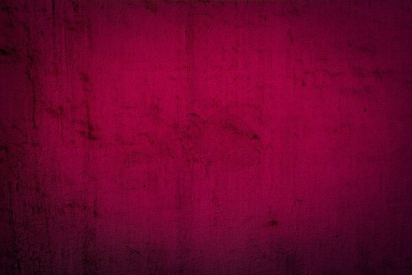 Старая красная стена в пятнах, трещинах, пятнах. Раскрашенная бетонная стена в абстрактном гранж стиле лофта. Фон старинной стены для фона, портретов, плакатов.