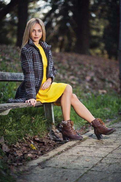 Mulher Loira Vestido Amarelo Casaco Está Sentado Banco Parque — Fotografia de Stock