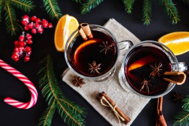 Noel arkaplanında tarçınlı ve portakallı iki bardak şarap. Noel içkileri, kış konsepti. Düz yatış, üst görünüm, yakın çekim.
