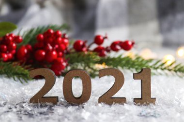 Noel ağacı ve kırmızı böğürtlenlerle bulanık bir arka plan oluşturan 2021 numaralı şenlik. Güzel yeni yıl kartpostalı. Yılbaşı tatili geçmişi. Yaklaş, seçici odaklanma.
