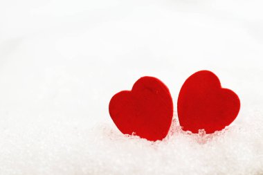 Beyaz karlı arka planda iki tahta kırmızı kalp. Yakın plan. Uzayı kopyala Sevgililer Günü konsepti. Aşk