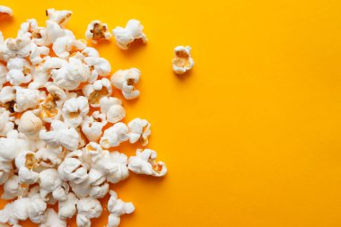 Sarı arka planda patlamış mısır. Sinema konsepti. Üst görünüm, yakın plan, düz görünüm, metin için kopyalama alanı