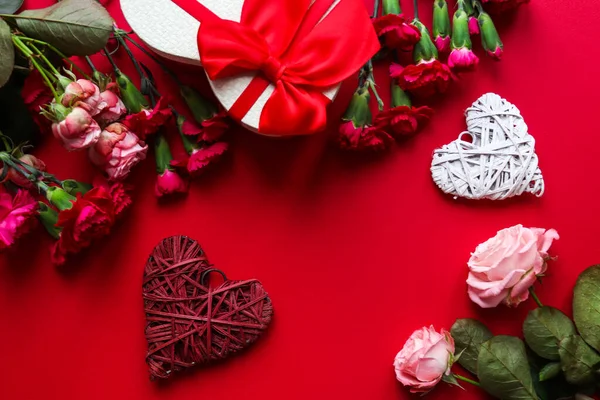 Hermosa tarjeta de felicitación del día de San Valentín. Corazón decorativo, caja de regalo en forma de corazón y flores sobre fondo rojo de cerca con espacio para copiar. Vista superior, plano —  Fotos de Stock